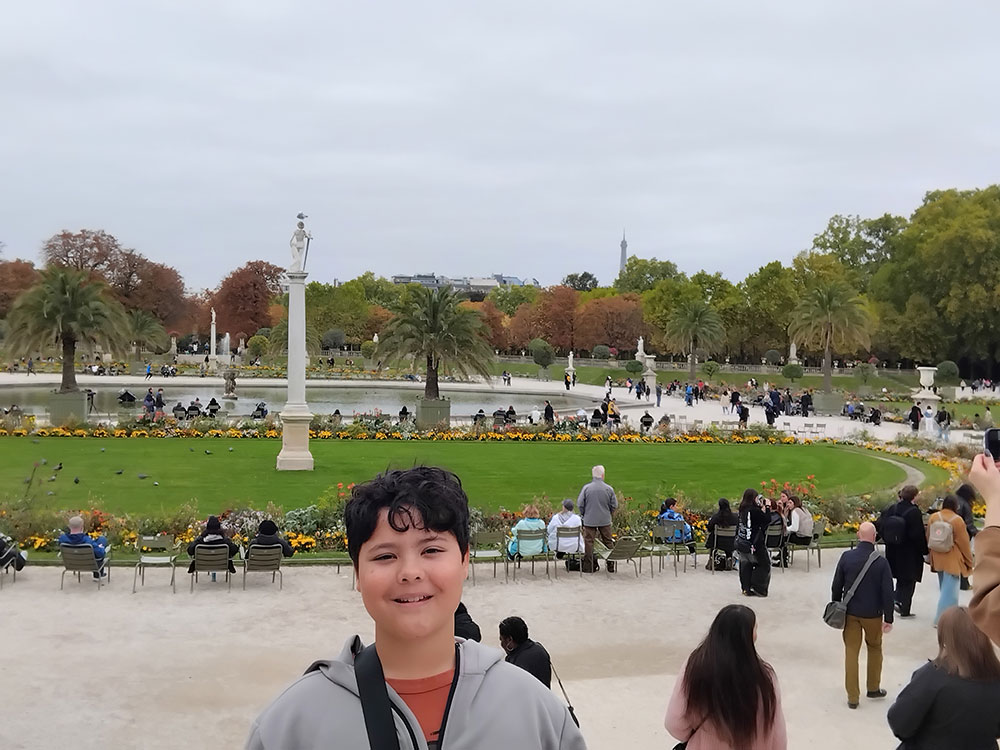 Luxembourg-Gardens Boy smiling in front of the obelisk at the Luxembourg gardens