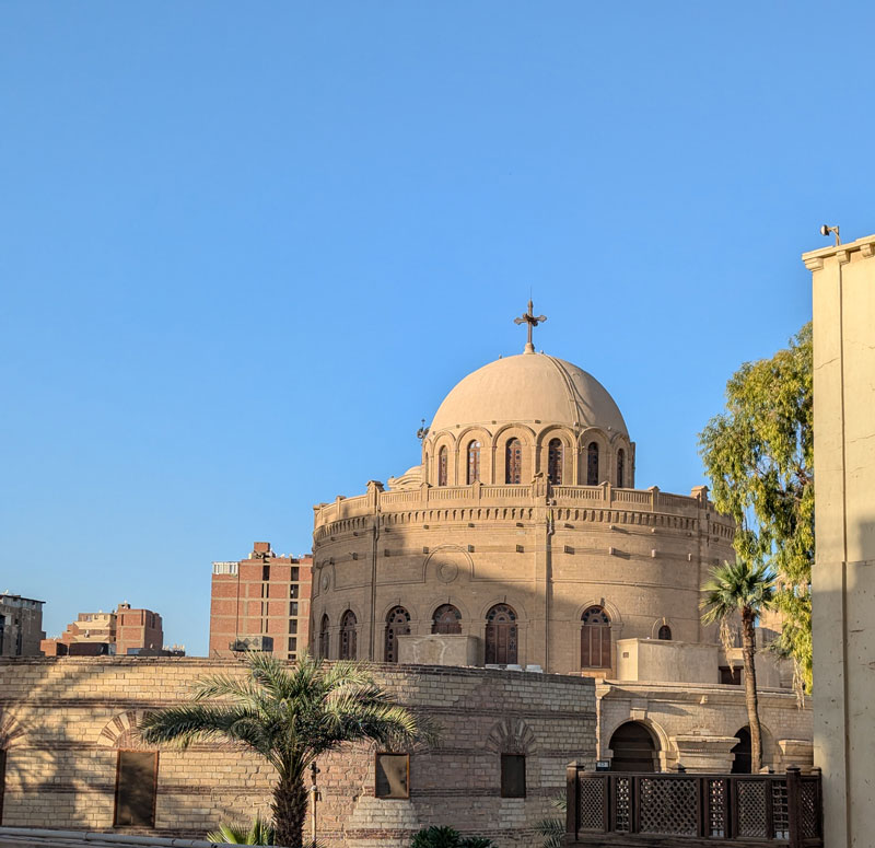Domed roof of St George's Church with a cross on top and it's circular walls